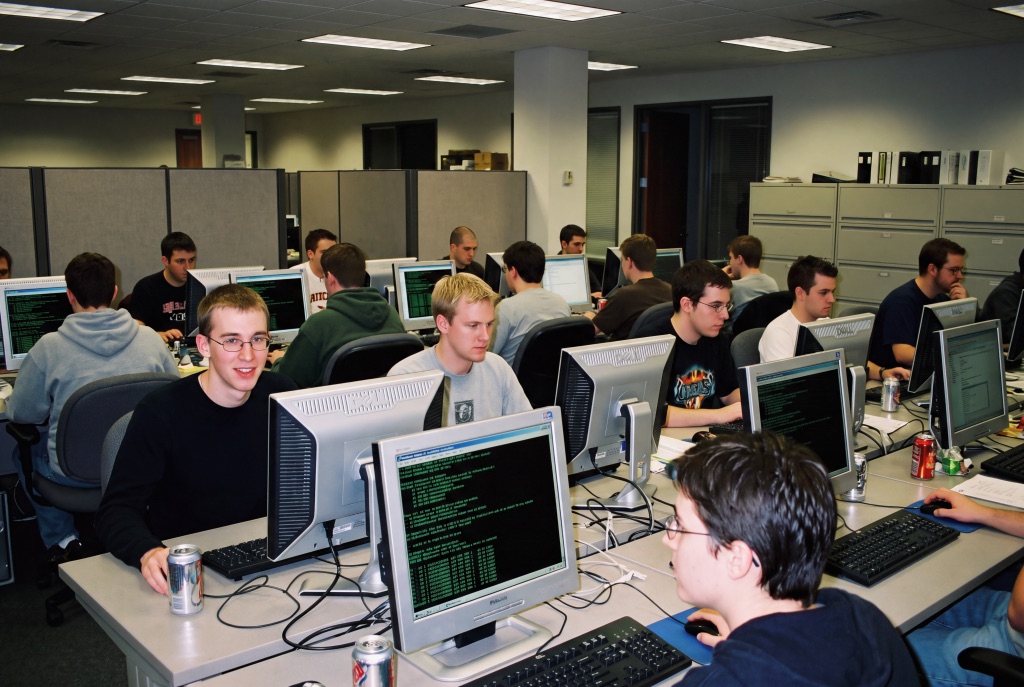 A crowded open-plan office packed with young people working at computers